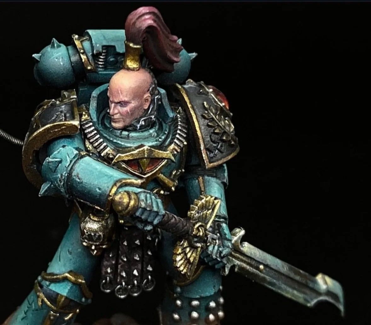 A detailed miniature figurine of a sci-fi warrior in ornate armor, wielding a sword, with a large backpack and a mohawk hairstyle, set against a black background.