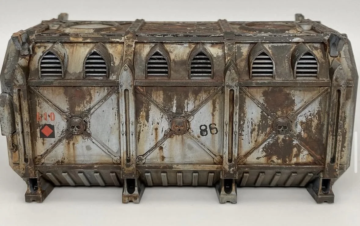 A heavily weathered, rusty metal container or crate with small vents at the top and numbered '40' and '86' on its surface.
