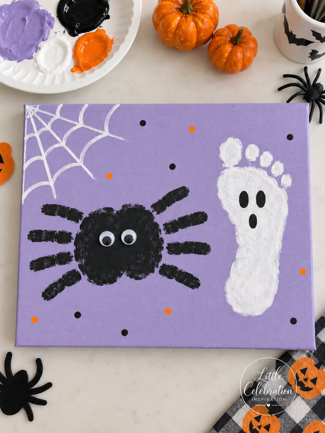 Lavender Halloween canvas featuring a black handprint spider and a white footprint ghost made by a child.