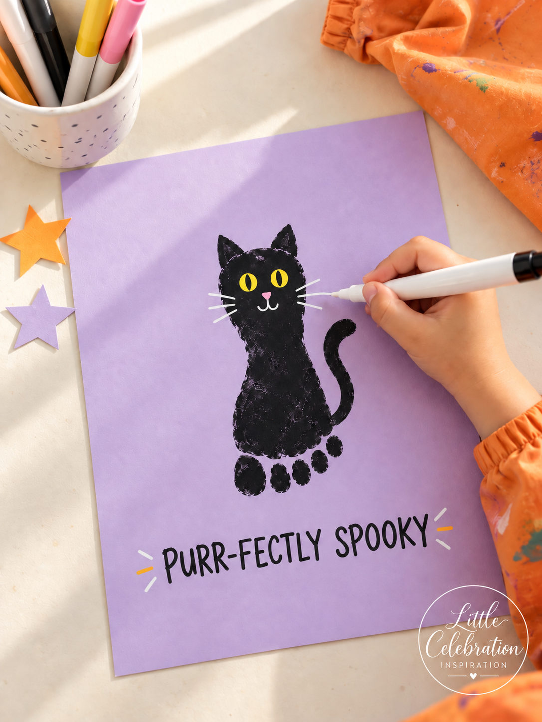 Black footprint cat craft on lavender paper with yellow eyes and white whiskers.