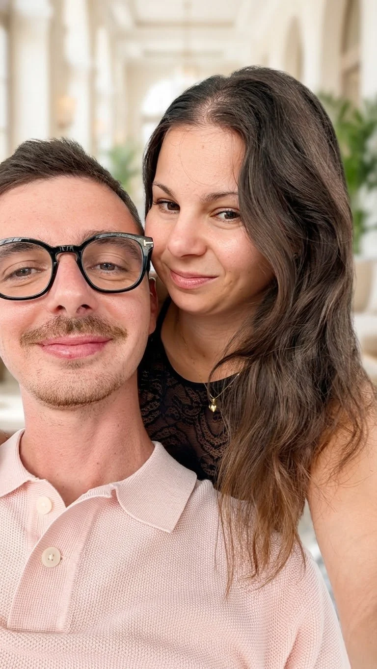 Due persone, un uomo e una donna, fanno un selfie insieme in un ambiente ben illuminato.
