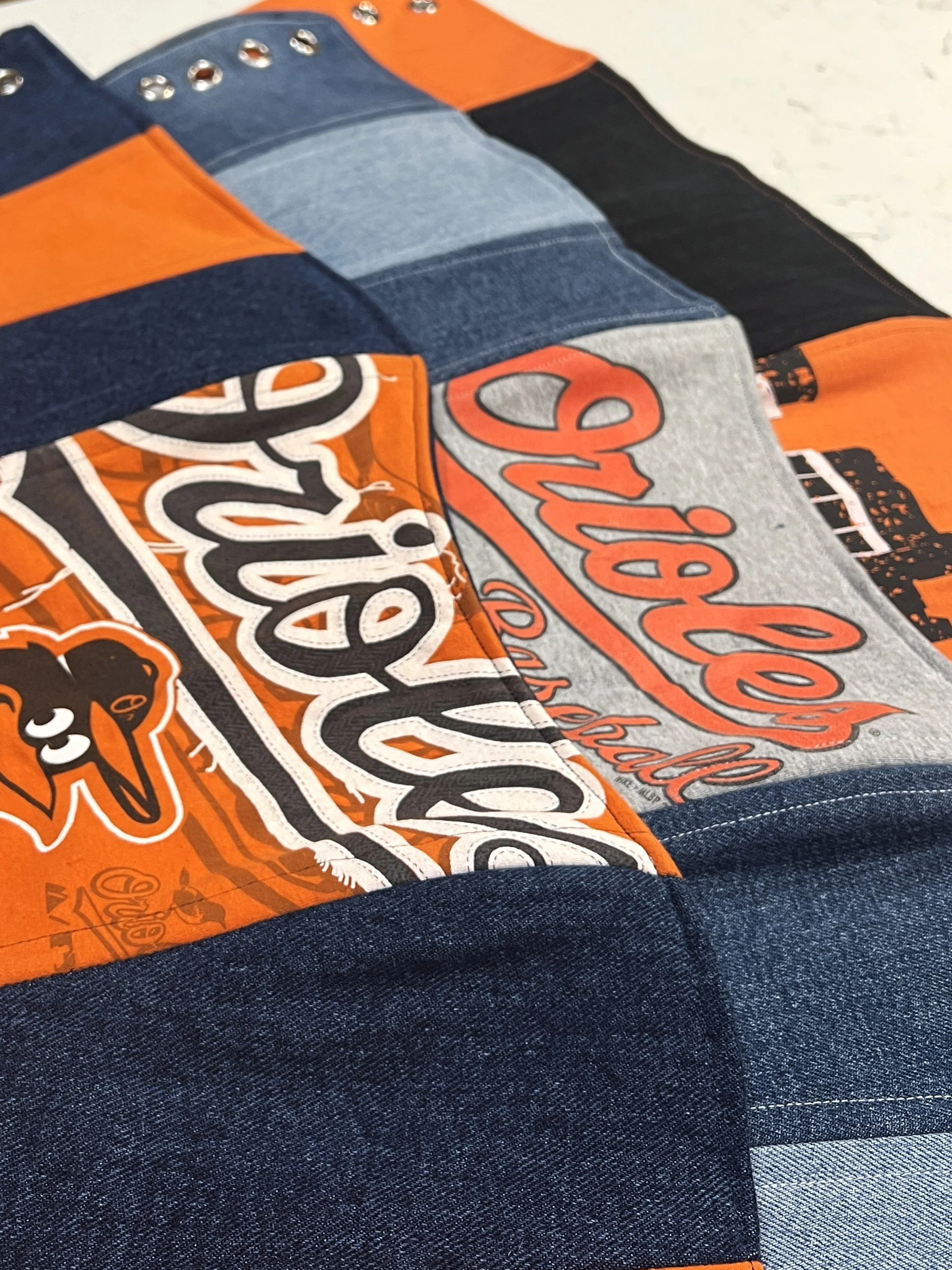 Three overlapping corsets made from recycled denim and orioles t-shirt designs.