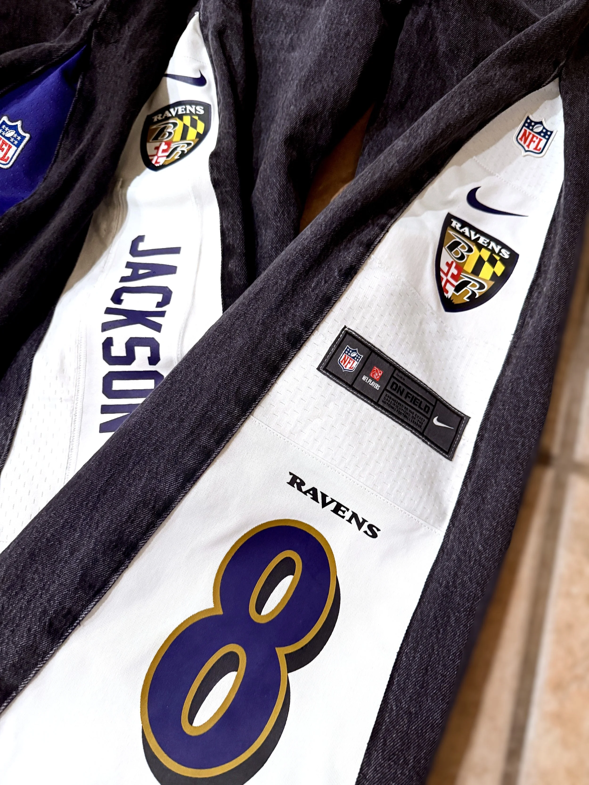 Close-up of a pair of flared jeans that highlight a white NFL jersey re-imagined.