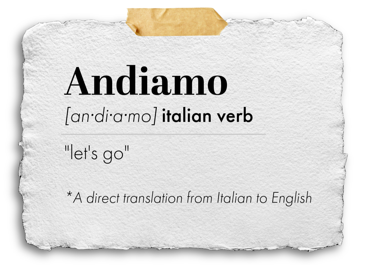 A piece of torn white textured paper with a piece of masking tape at the top. The paper displays the word "Andiamo" in large bold font, with its phonetic pronunciation and description as an Italian verb meaning "let's go," including a note that it is a direct translation from Italian to English.