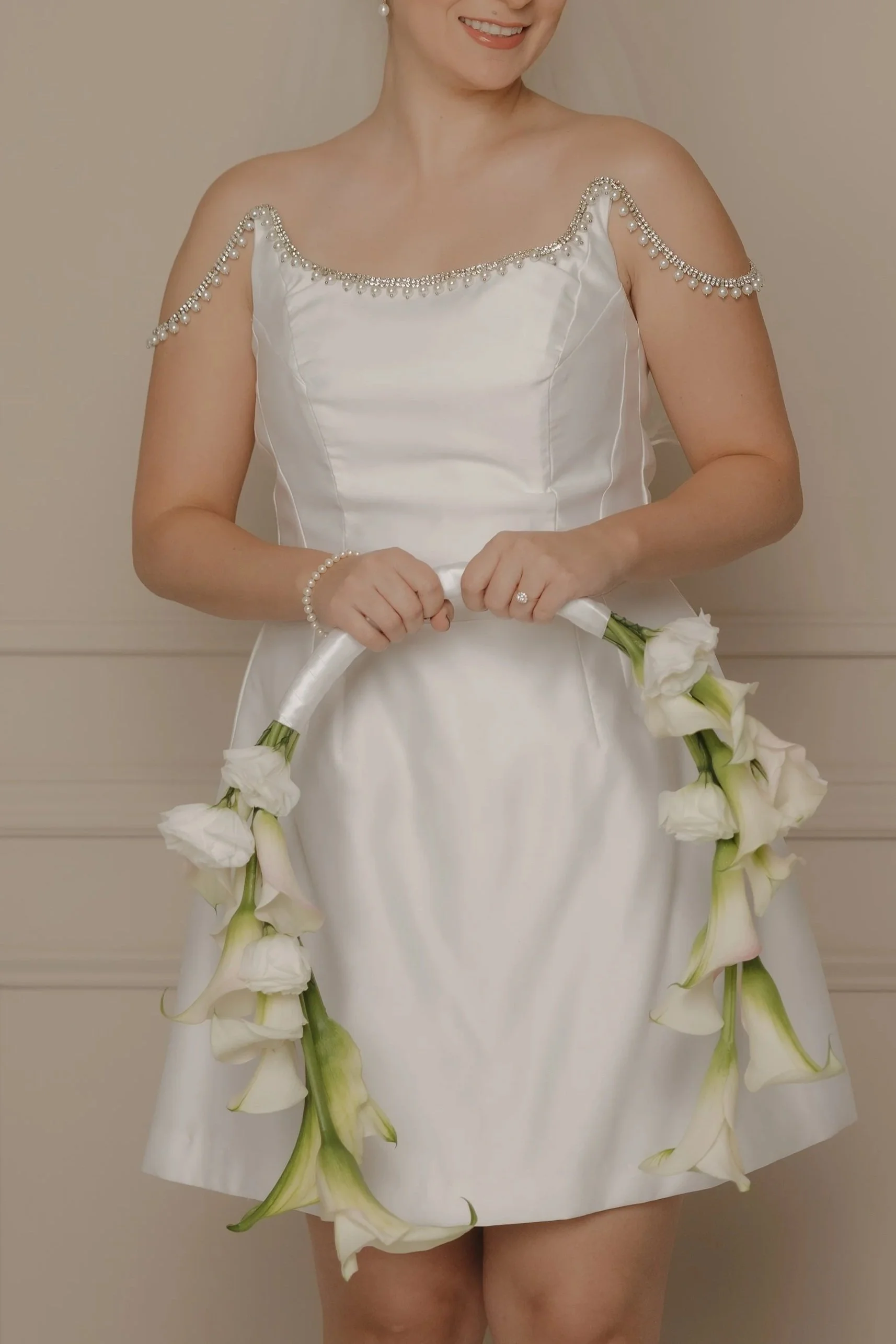 Novia sosteniendo un ramo floral de estructura circular con flores blancas