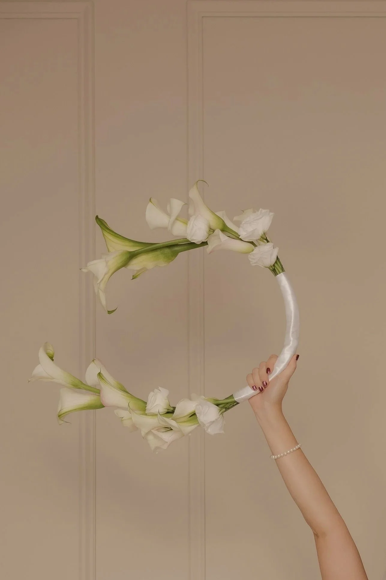 Novia sosteniendo un ramo circular decorado con flores blancas
