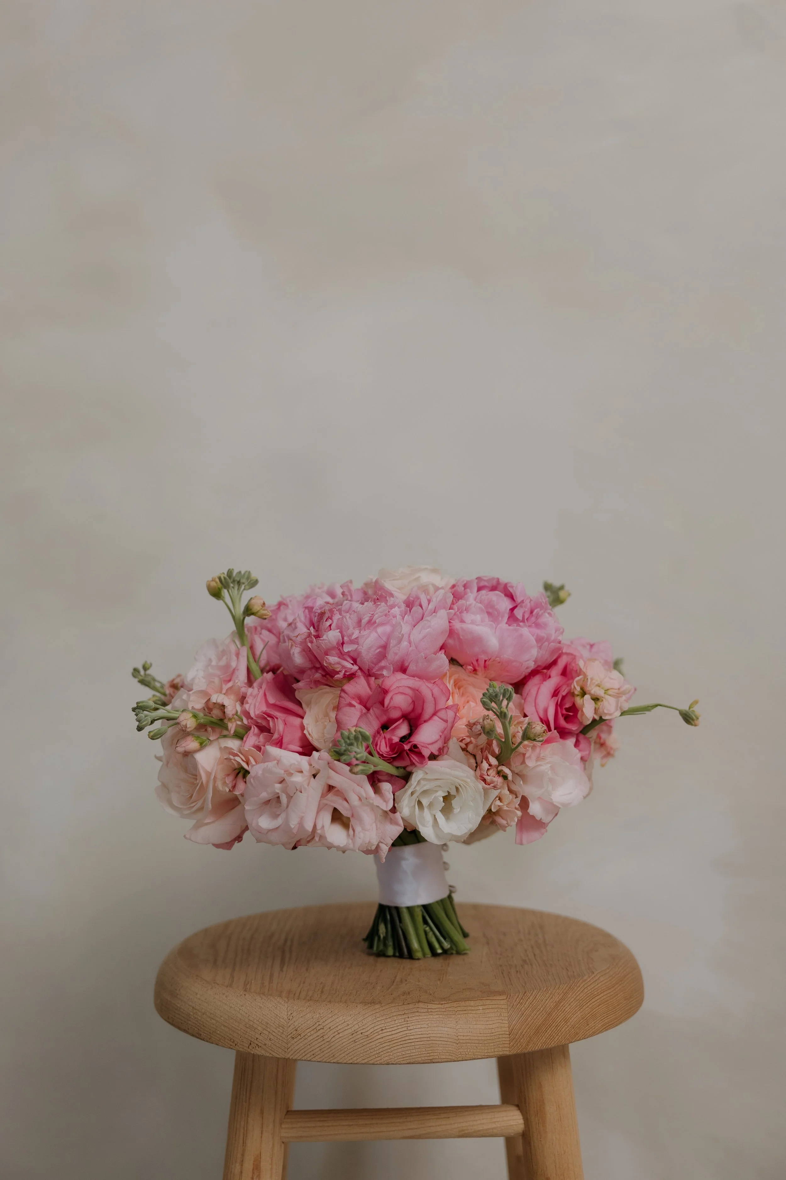 Ramo de novia clásico de peonias rosas y flores en tonos rosa pastel y durazno.