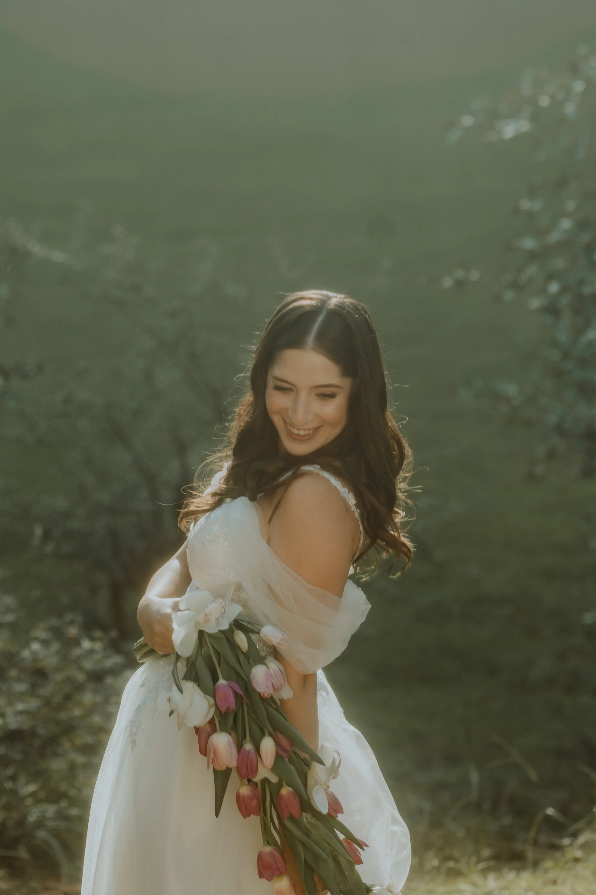 Novia al aire libre sosteniendo un ramo de flores blancas y rosa pastel