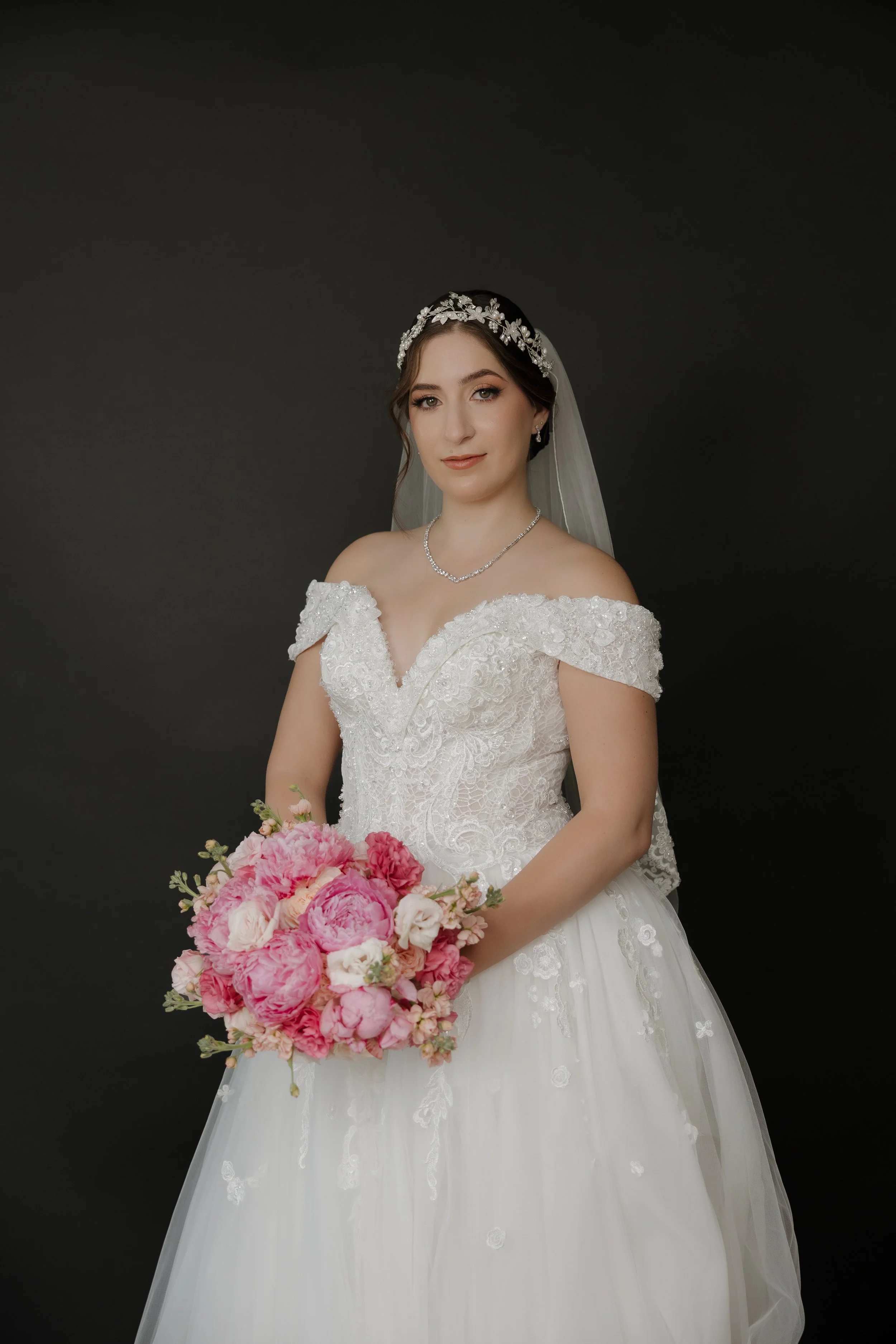 Lizeth vestida de novia sosteniendo su ramo de peonías rosas y blancas