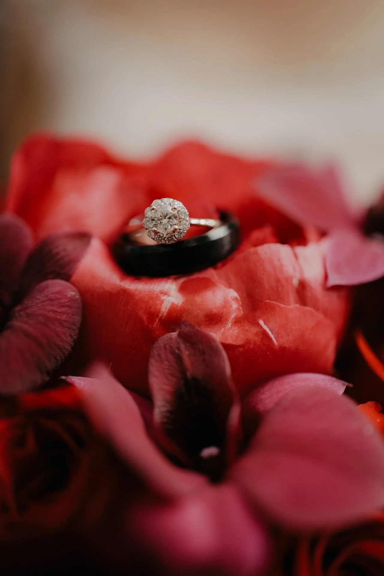 Ramo de novia con peonias rojas, rosas rojas y orquídeas dendrobium violetas, con anillos de compromiso.