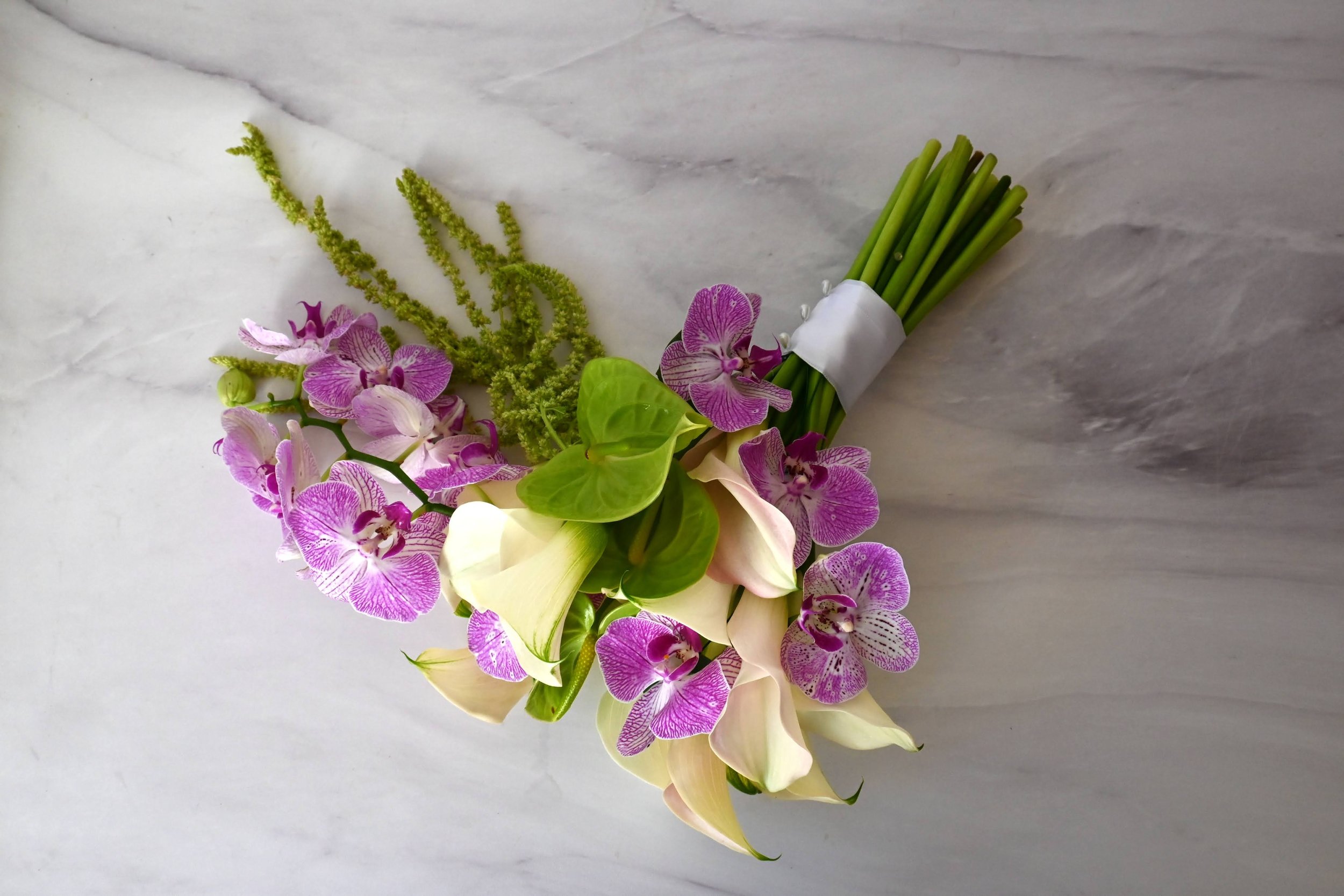 Ramo de novia editorial con orquídeas moradas, anturios verdes, callas y amaranto