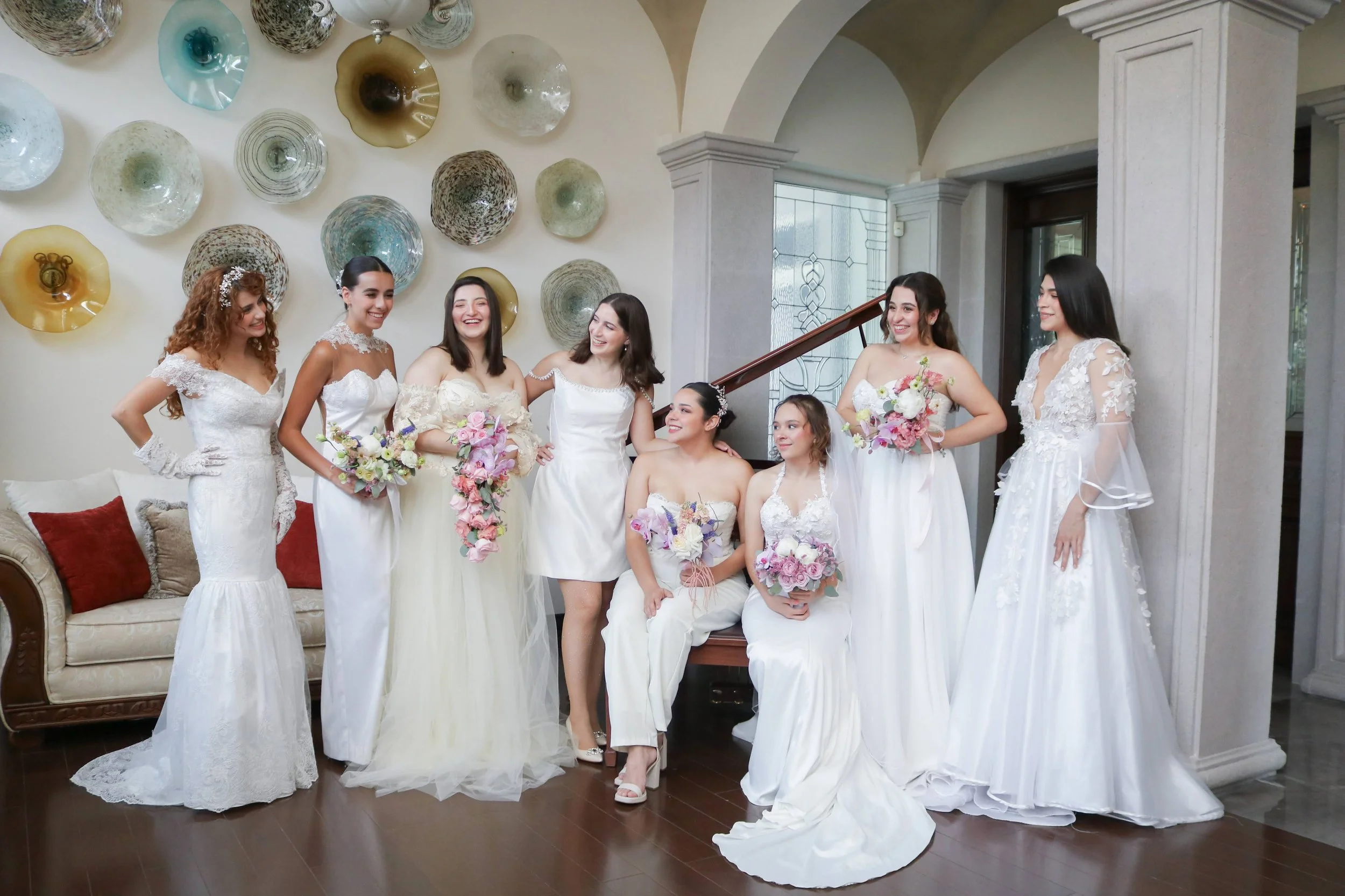 Lizeth junto a varias novias, cada una sosteniendo un ramo de diseño diferente