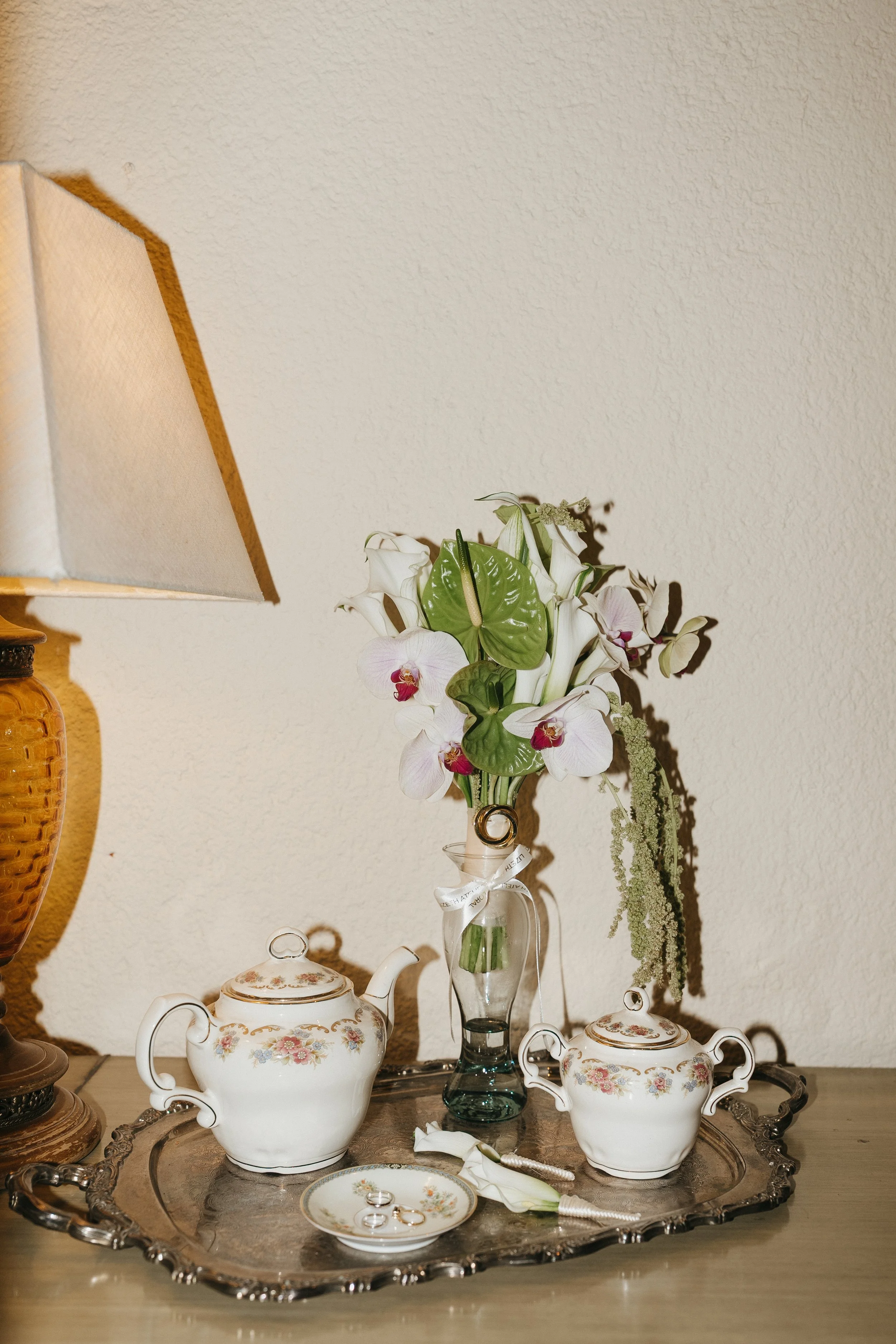 Ramo editorial de flores blancas y amaranto verde presentado sobre una mesa