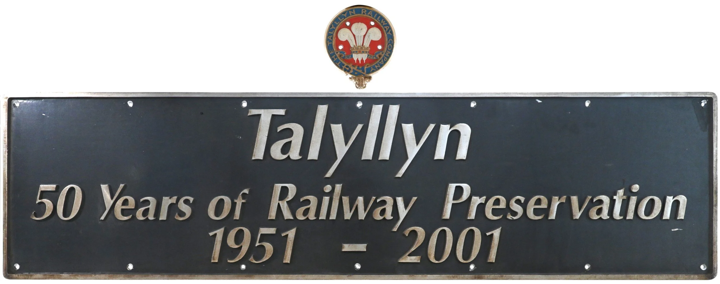 A metal locomotive nameplate commemorating Tallyn's 50 years of railway preservation from 1951 to 2001, with a badge or emblem above it.