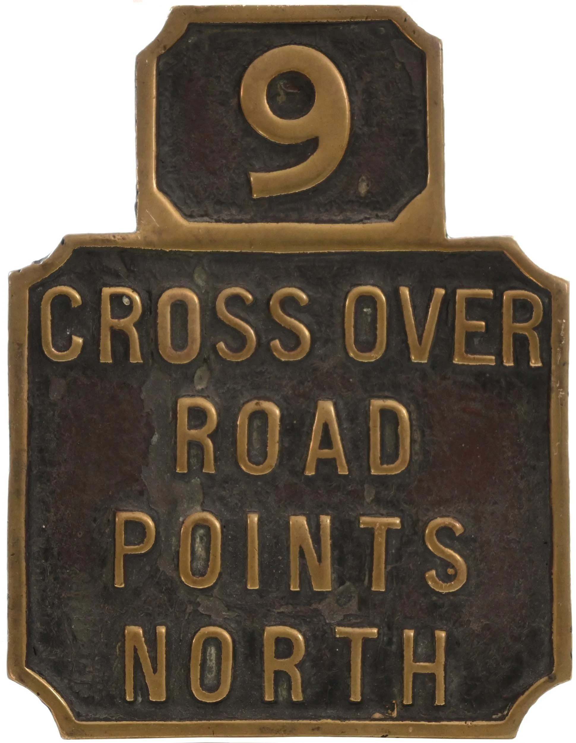 A brass lever lead that reads 'Cross Over Road' with the number 9 at the top.