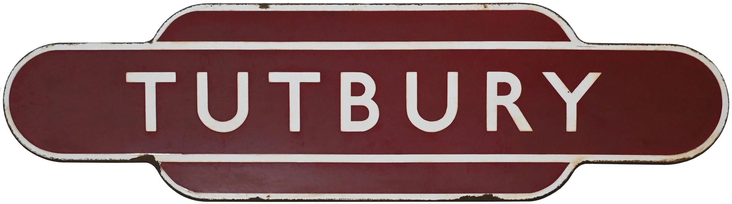A railway station Totem sign with a maroon background and white letters spelling 'TUTBURY', surrounded by a white border with slightly worn edges.