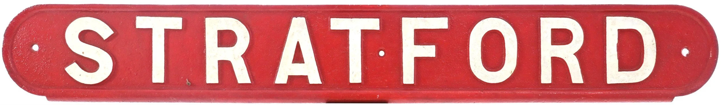 Red vintage railway seatback sign with white letters spelling 'Stratford'.