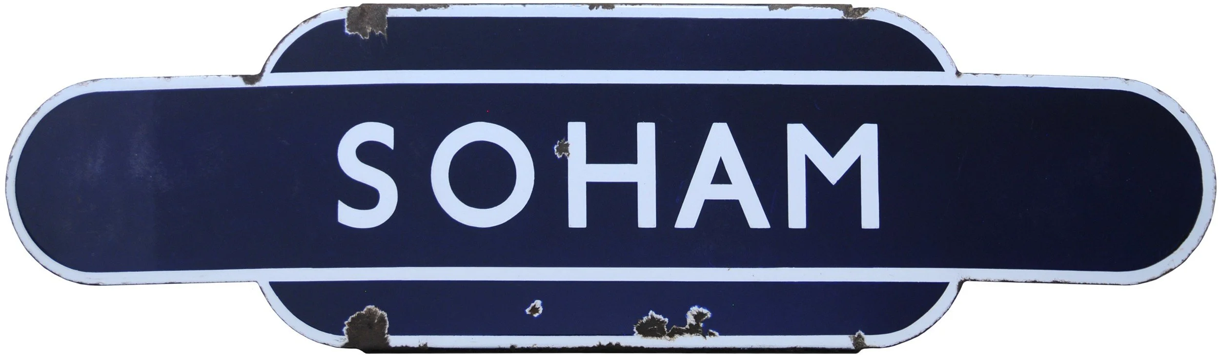 A white and navy blue railway station Totem sign with the word 'SOHAM' in white uppercase letters.