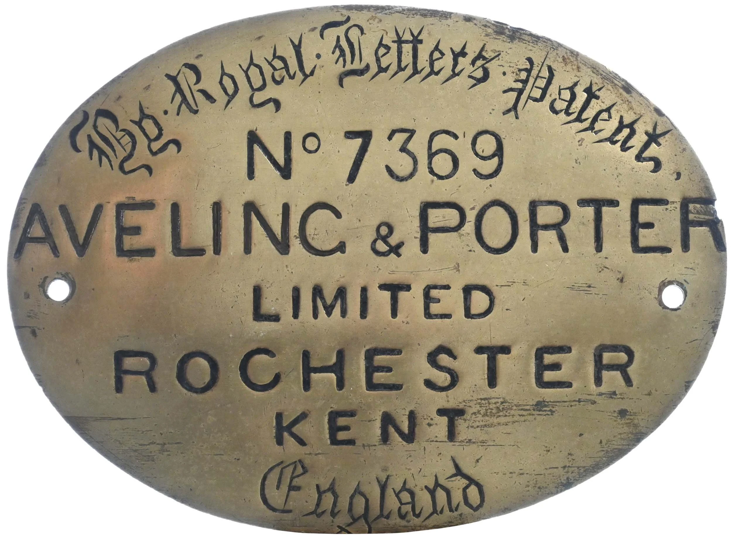 Close-up of a vintage brass plaque with black engraved lettering. The text reads 'Royal Silver Patents No 7369 Aveling & Porter Limited Rochester Kent'. The plaque has round holes on either side, possibly for mounting.