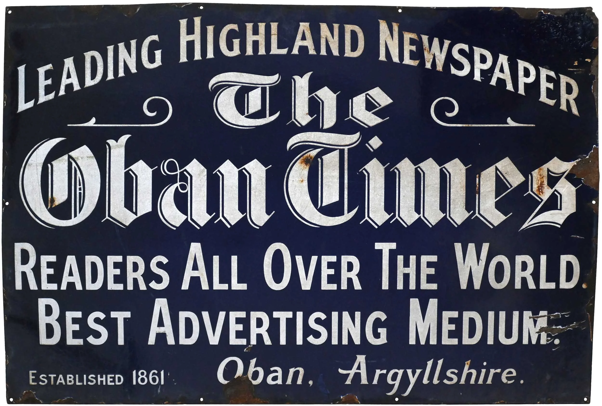 Old sign with the text 'Leading Highland Newspaper-Paper The Tribune' and additional text about the publication, noting it was established in 1861 in Oban, Argyllshire. The sign is weathered and rusted.