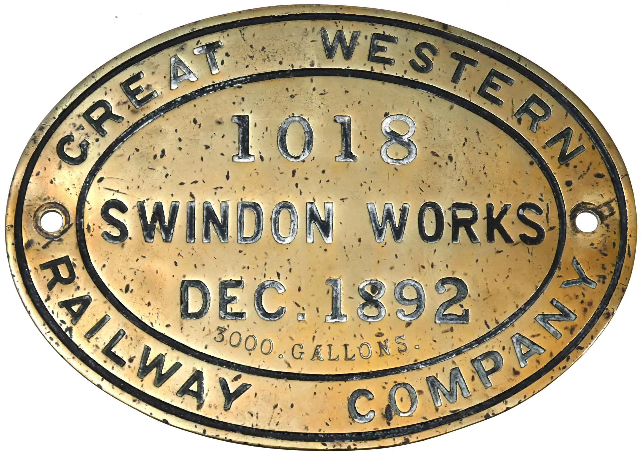 A vintage circular metal sign with black lettering on a gold background, displaying the text 'EAST WEST' at the top, '1018' in the center, and additional surrounding text about a window works company established in December 1892, with an indication o
