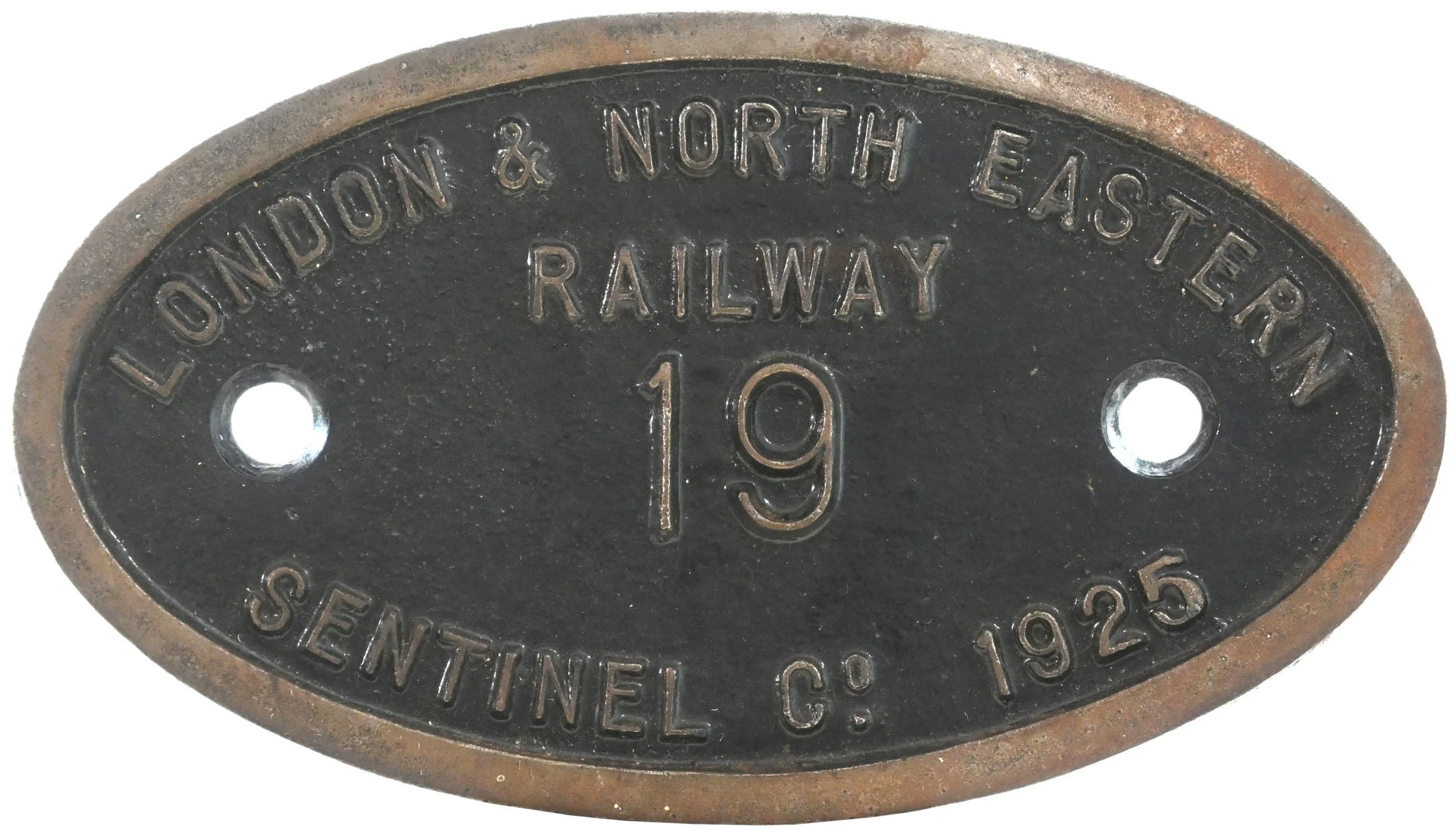 Close-up of an oval metal railroad switch identification plate with embossed text, including the number 19, indicating it is from the London & North Eastern Railway, dating from 1925.