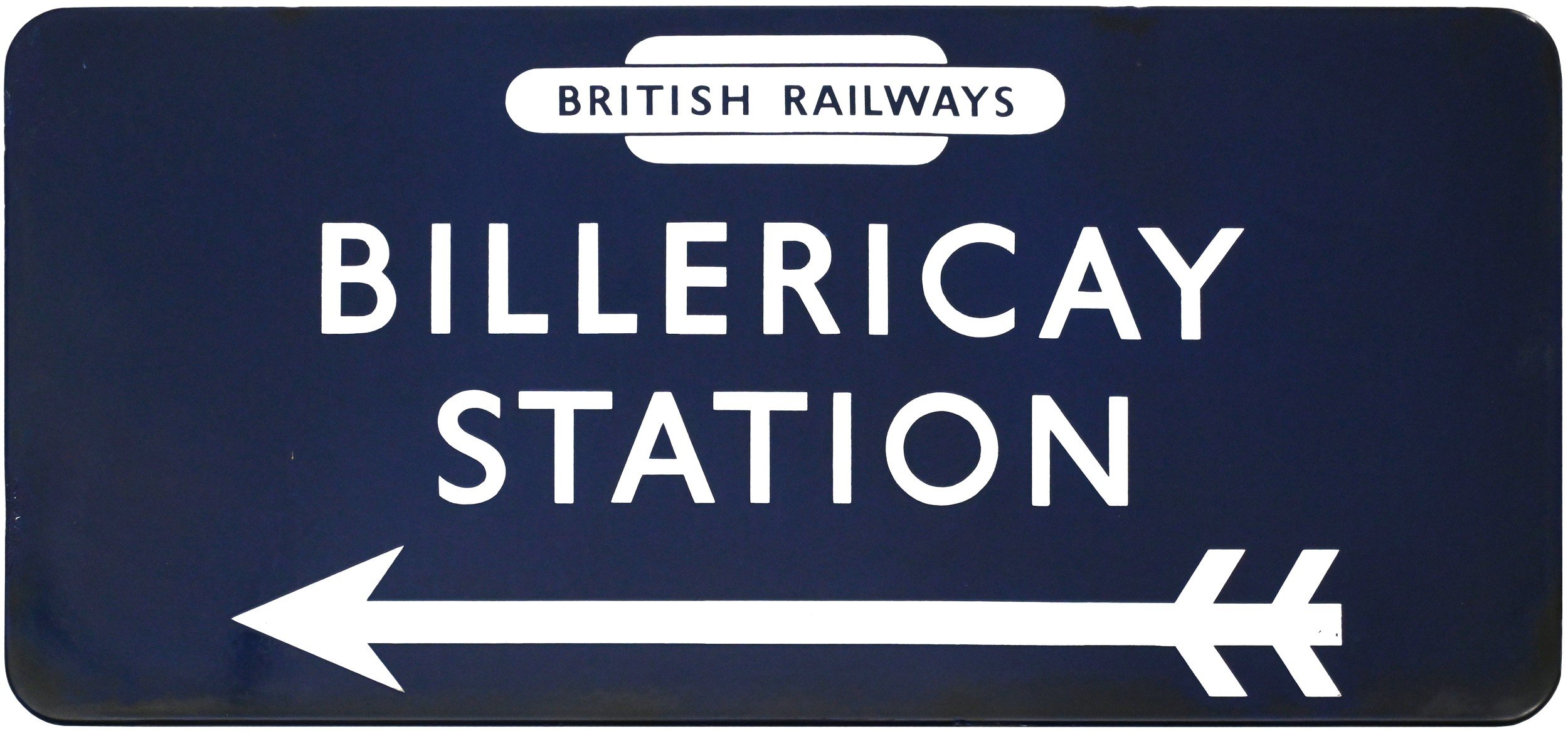 Blue directional sign for Billericay Station with a white arrow pointing left.