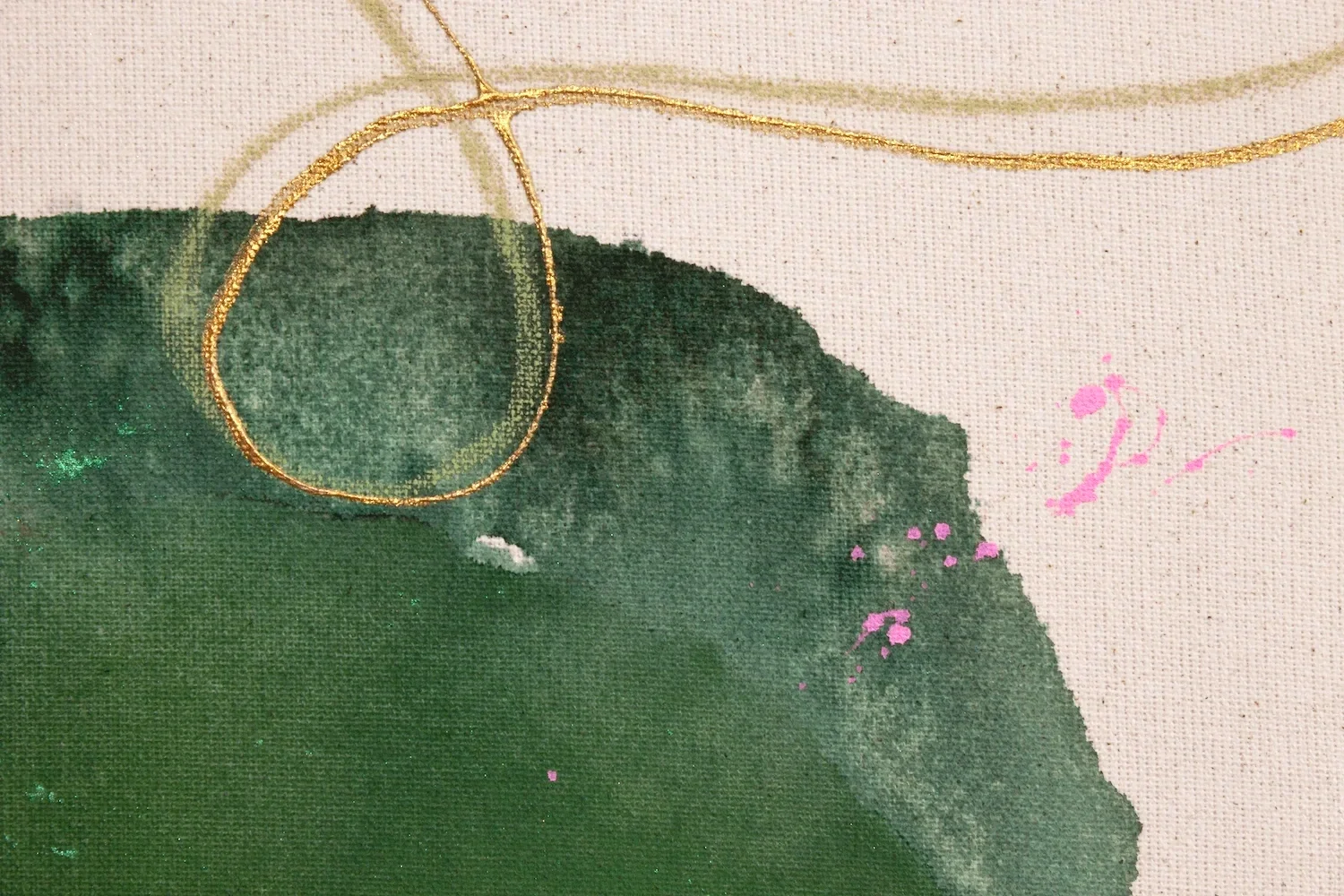 Nahaufnahme einer Leinwand mit grüner Aquarellfarbe, goldener Draht und pinken Spritzern.