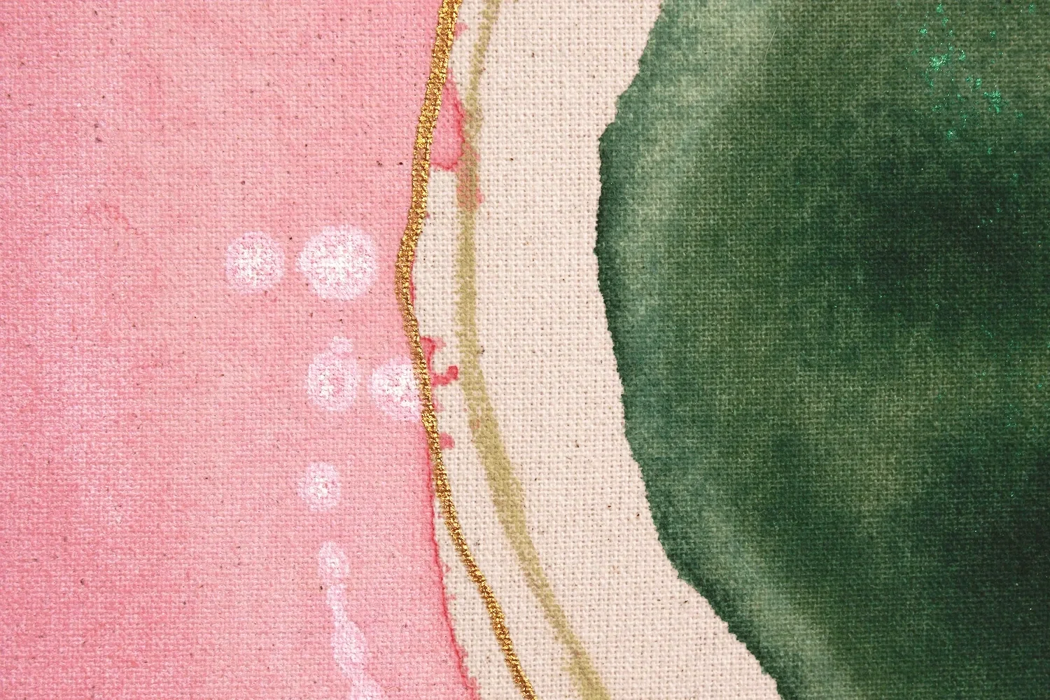 Nahaufnahme eines geometrischen Musters in Pastellfarben, bestehend aus Pink, Weiß und Dunkelgrün, mit goldenen Akzenten und Textur des Stoffes sichtbar.