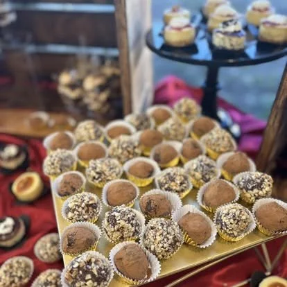 Assorted truffles and chocolates on a gold tray and a black stand.