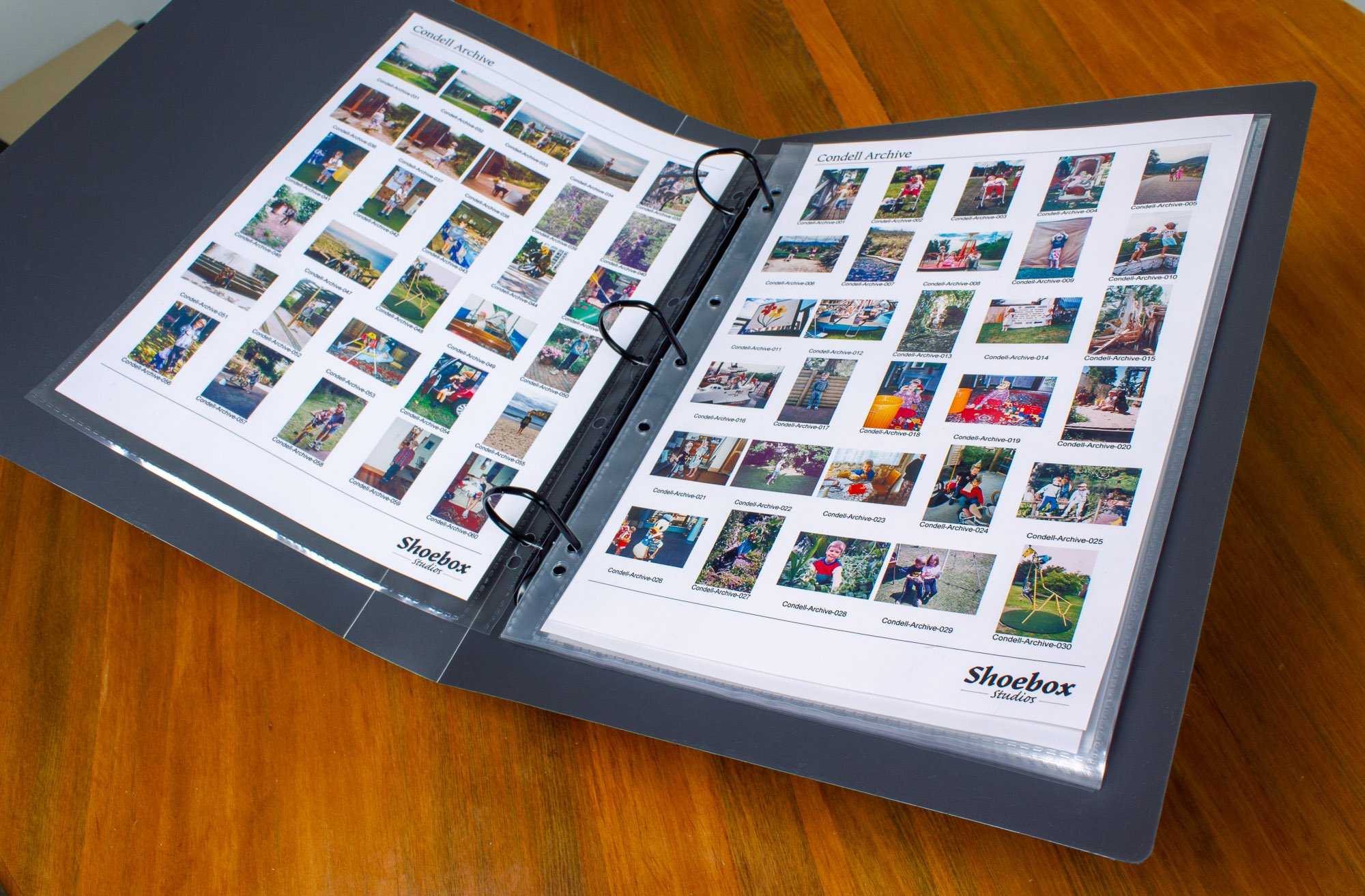 Open photo album or scrapbook titled 'Condell Archive' with multiple rows of printed photographs, placed on a wooden surface.