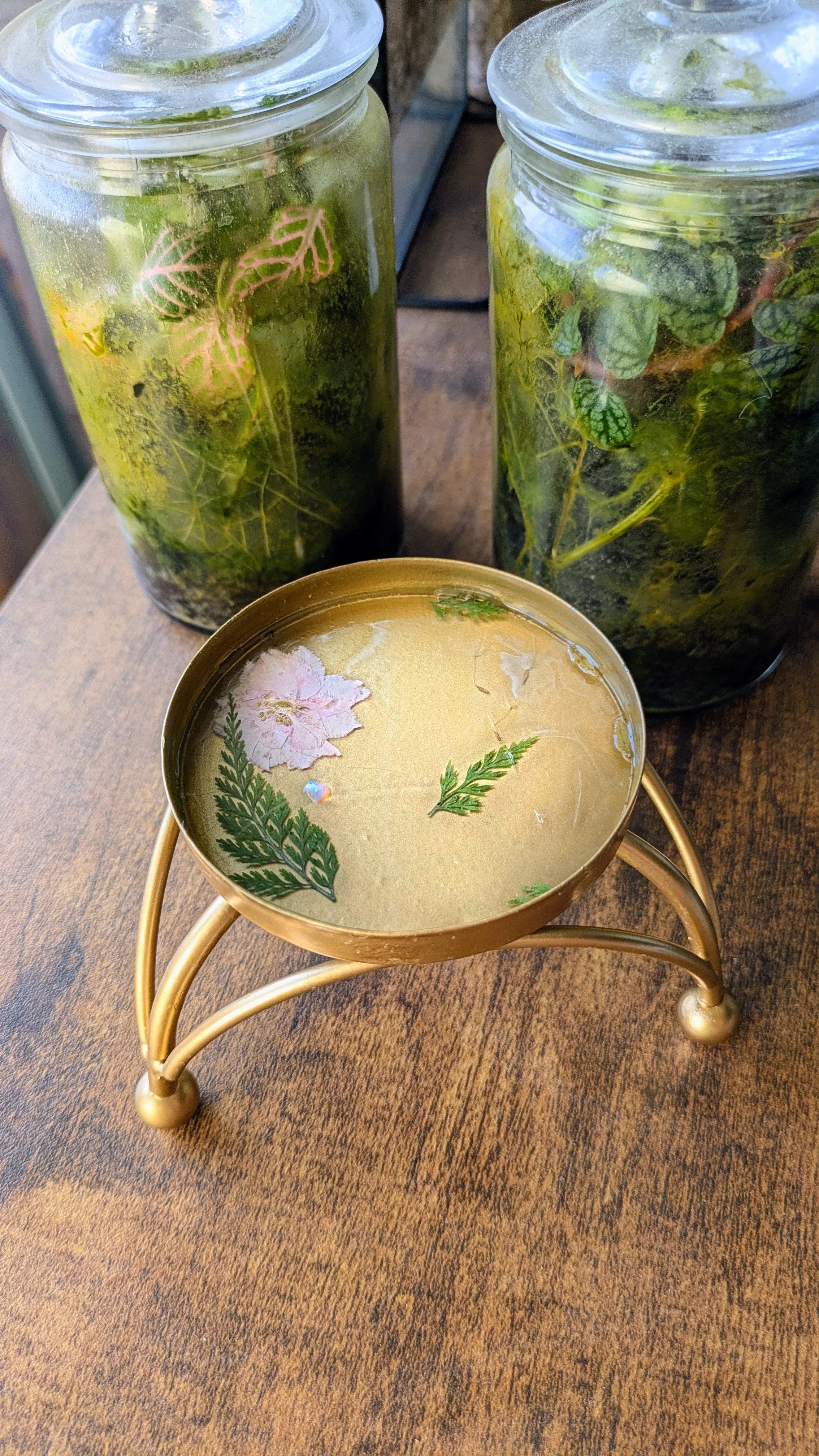 gold jewelry holder filled with leaves, a flower and a real opal set in resin.