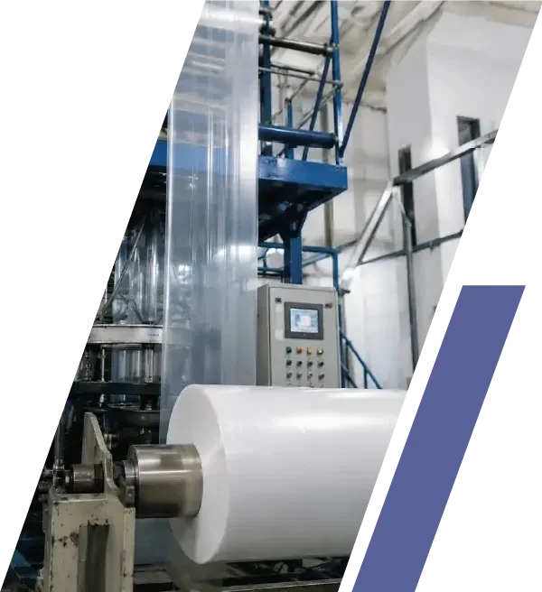 Maquinaria industrial para producción de empaques, con un rollo grande de material plástico en proceso de fabricación.