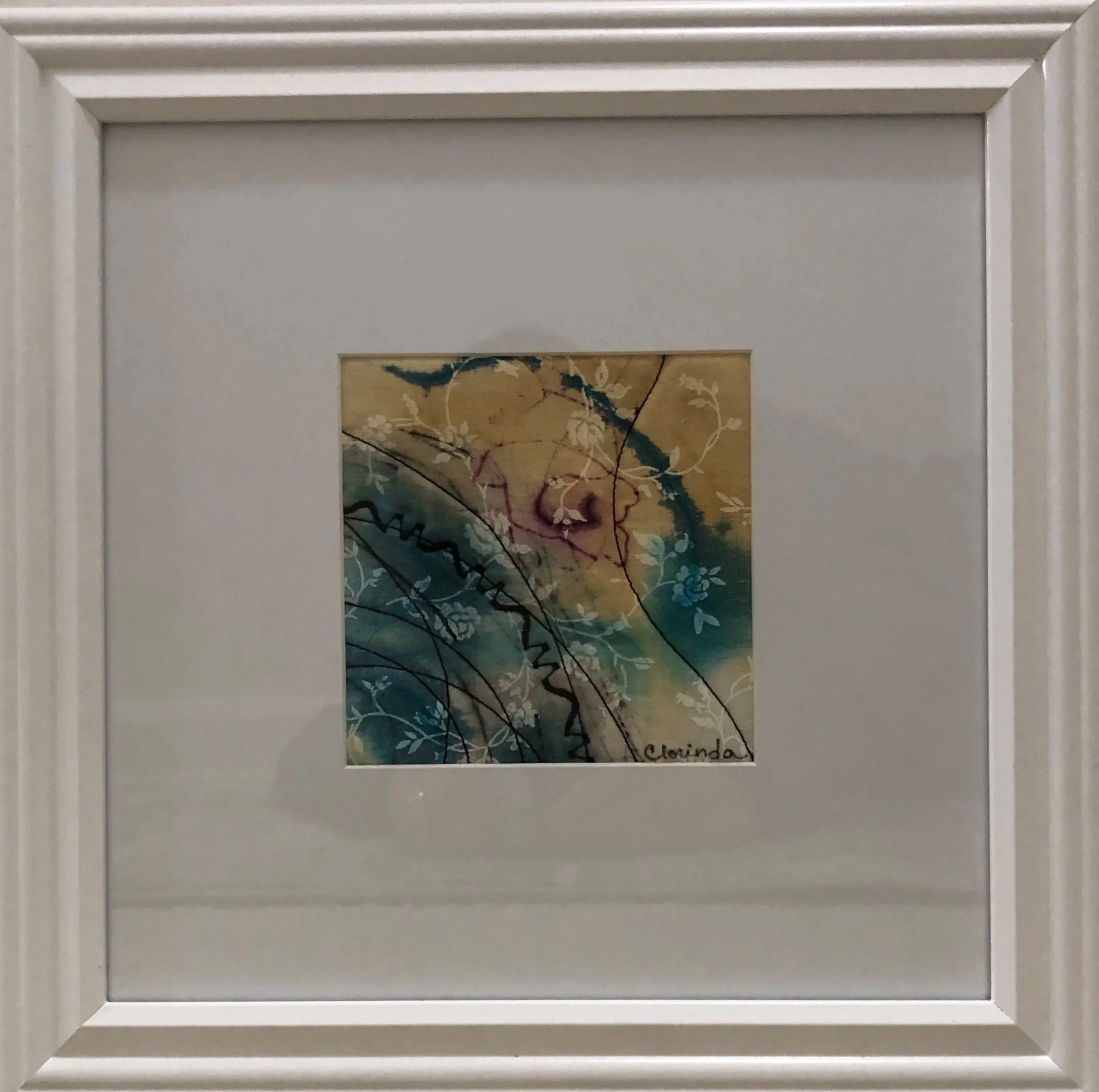 A framed piece of artwork, abstract design, featuring swirling lines, floral patterns, and a mix of dark and light colors including shades of purple, yellow, and blue signed with the name 'Clorinda'.