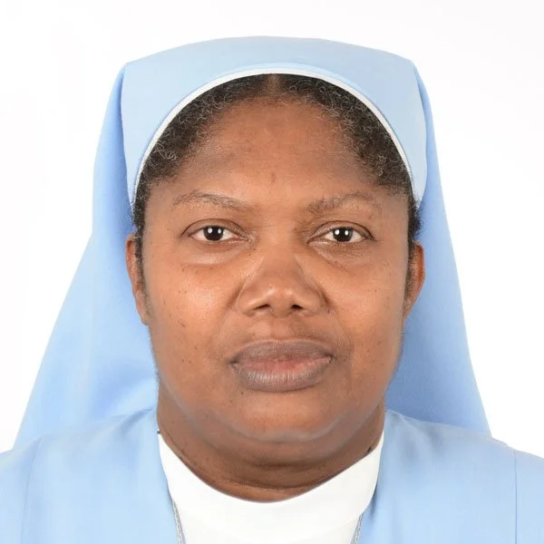 A woman dressed as a nurse with a light blue uniform and matching cap, facing forward with a neutral expression.
