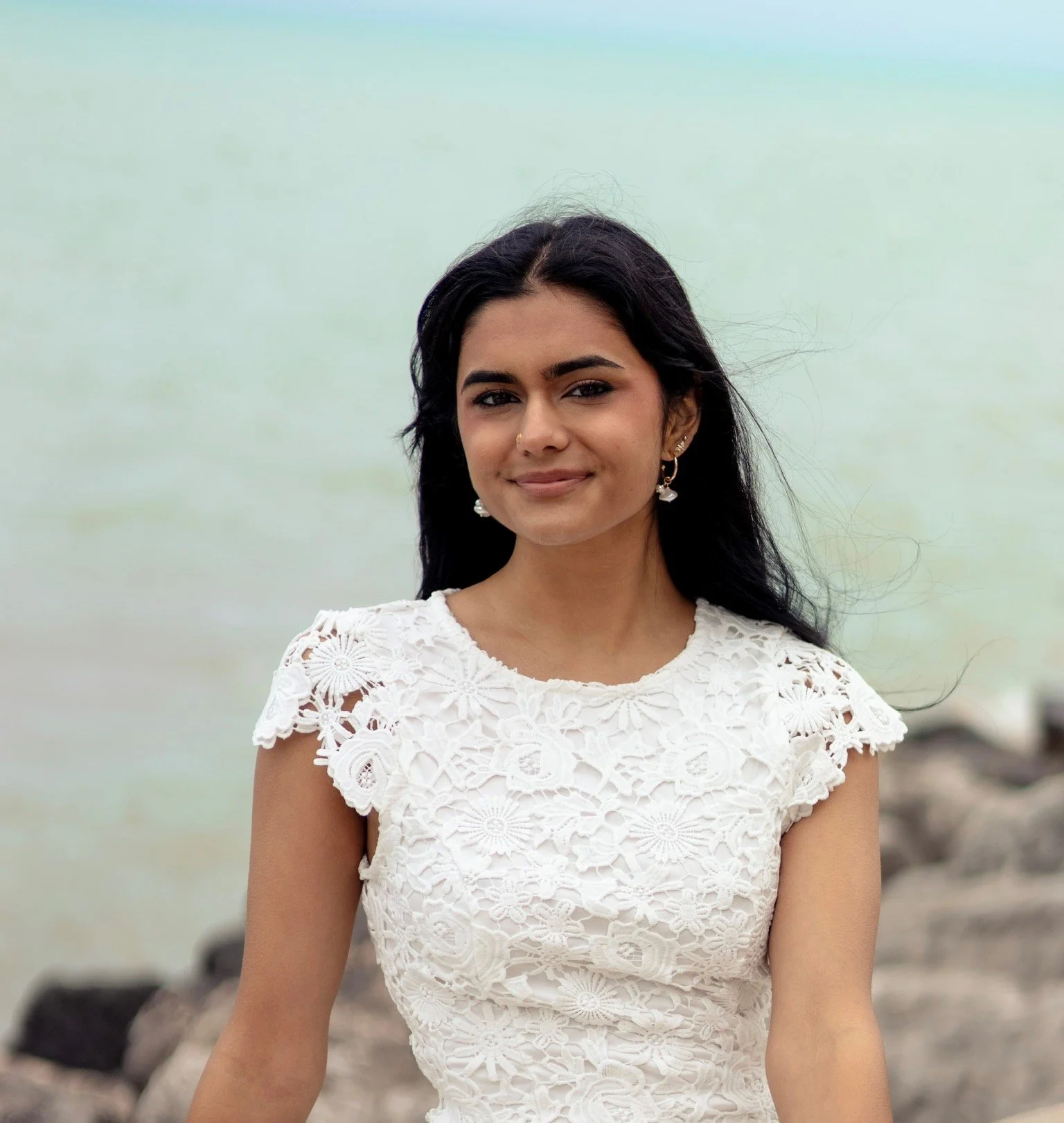 Photo of Harmony smiling to camera, standing in front of ocean.
