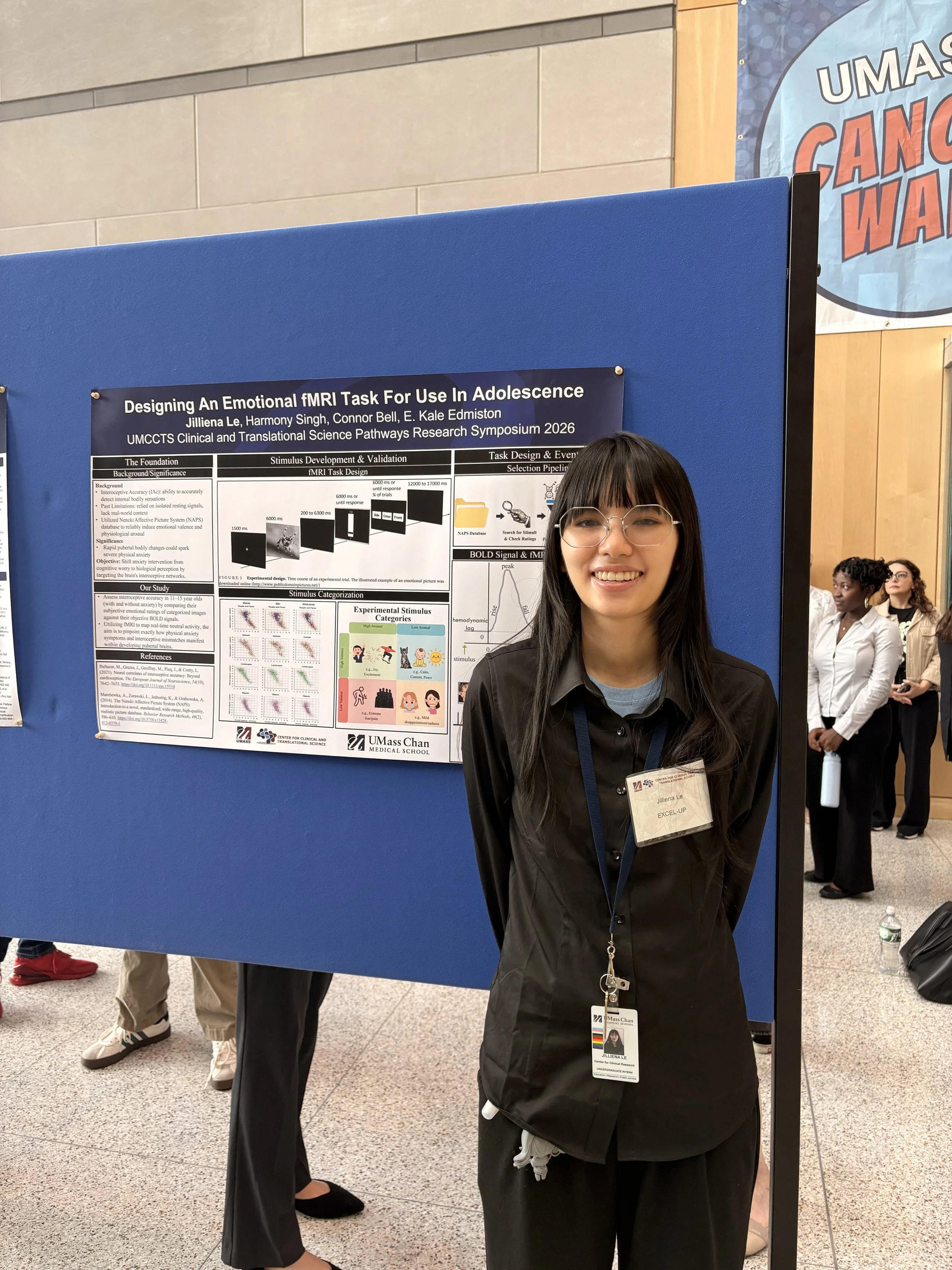 Photo of Jilliena standing in front of science poster at a conference.