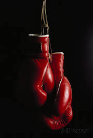 Red boxing gloves hanging against a black background.