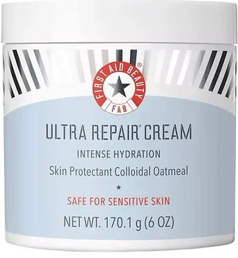 A container of First Aid Beauty Ultra Repair Cream, a skincare product for intense hydration, labeled as safe for sensitive skin and containing colloidal oatmeal.