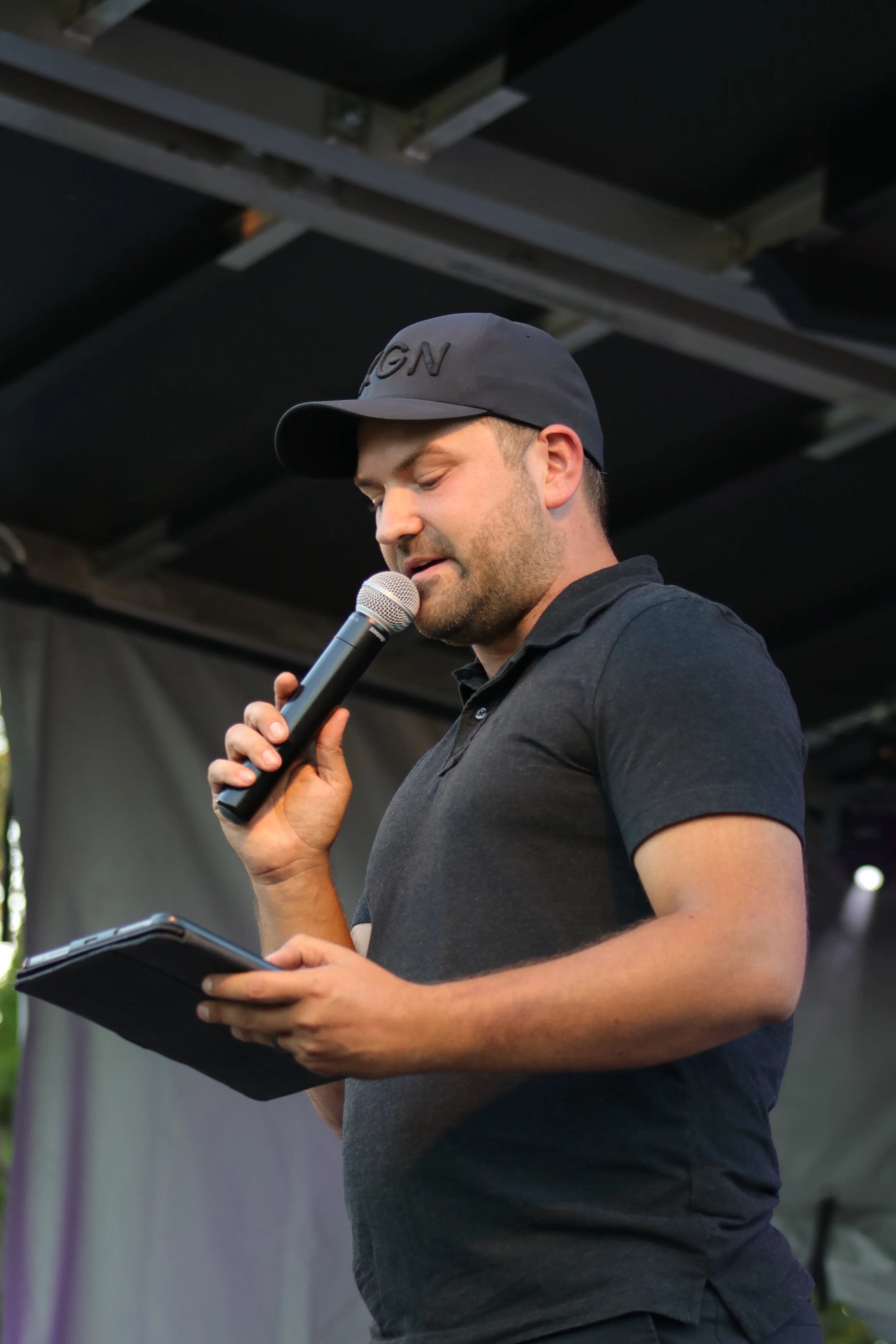 Nathan Keys speaking into a microphone at a community event.