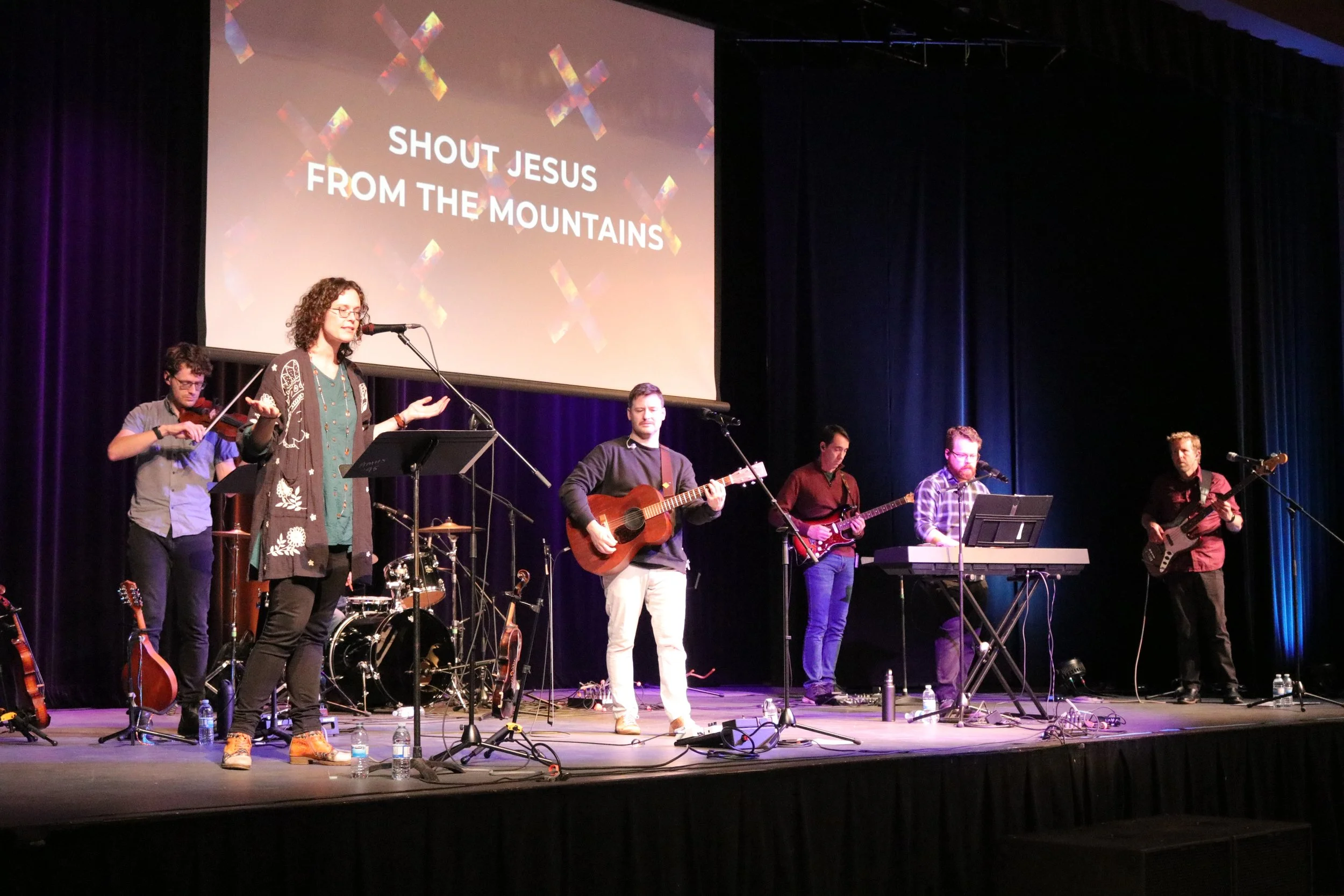 A worship band performing together on stage.