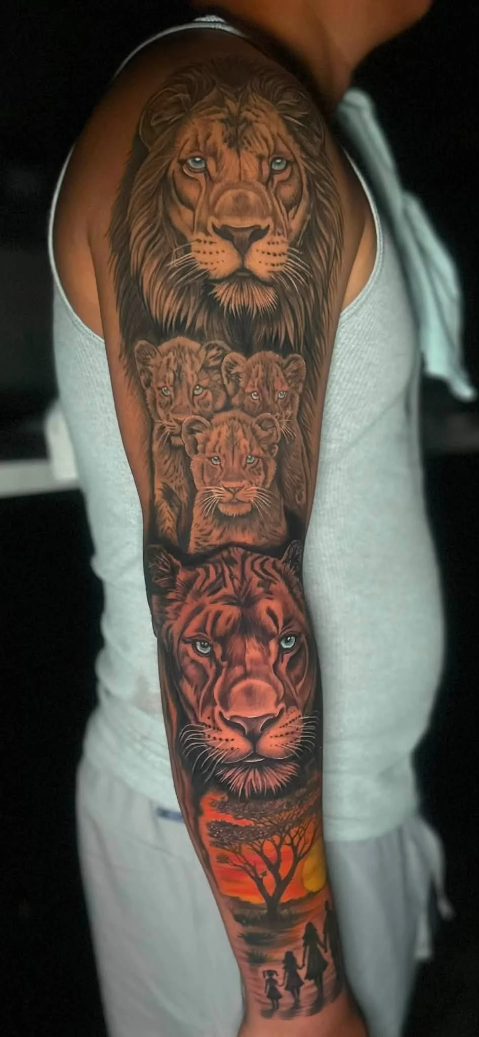 Tattoo of a lion's face at the top, followed by three lion cubs, a lioness, a sunset scene with trees, and two children holding hands.