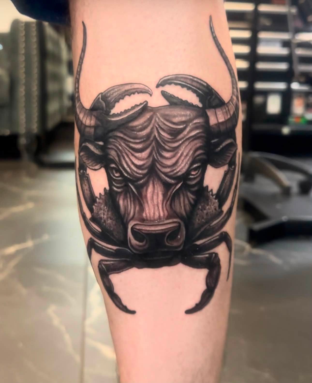Tattoo of a scorpion with a detailed bear's face on its back, on a person's arm.