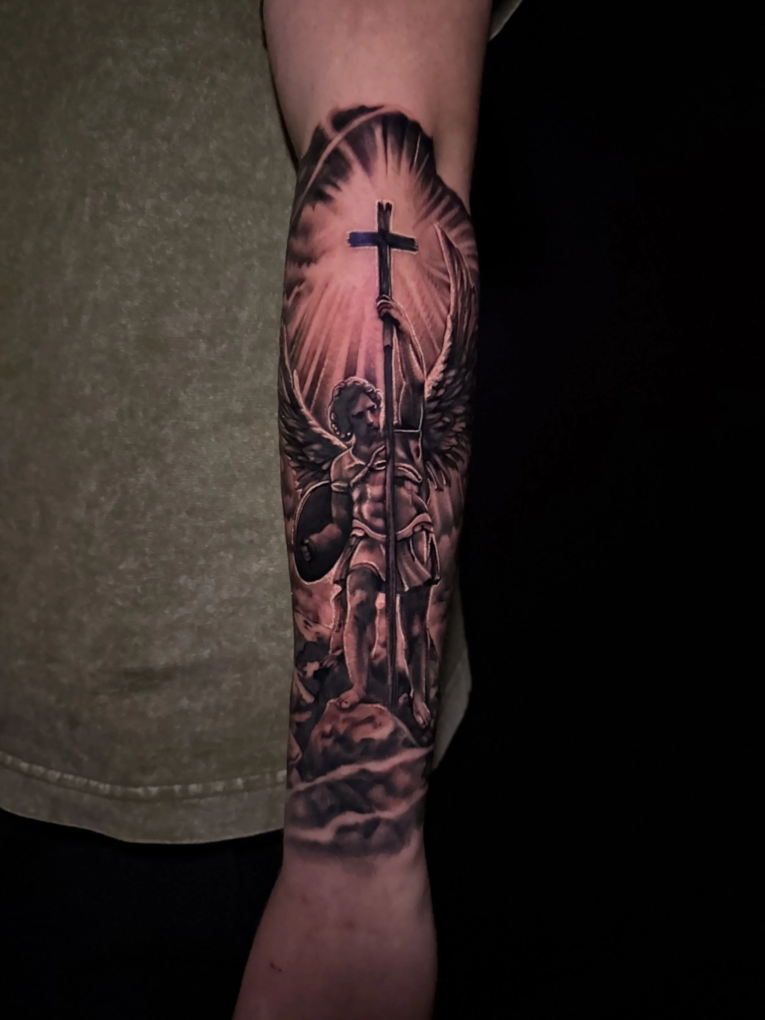 Tattoo of Jesus Christ carrying a cross on the forearm.