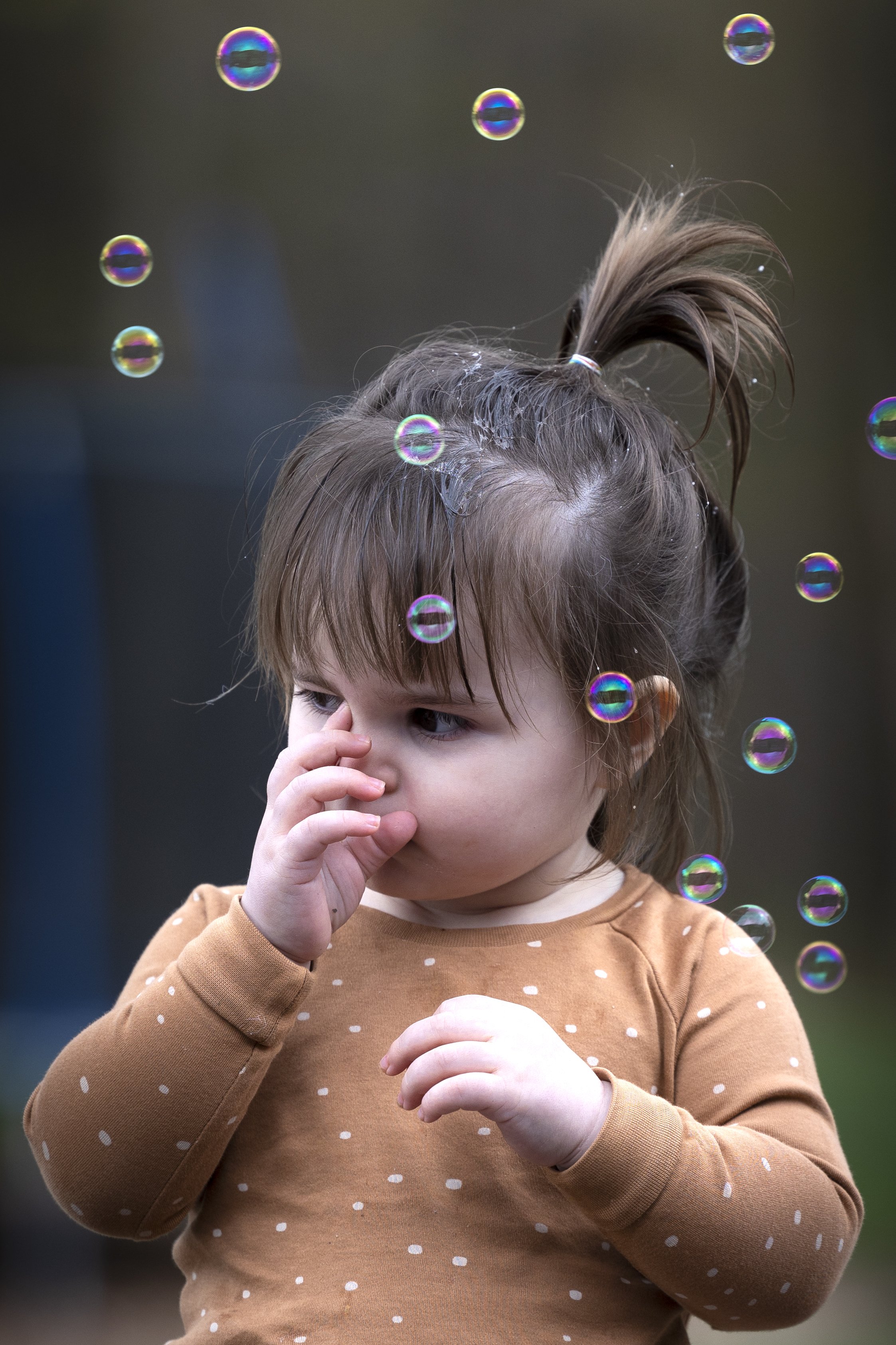 Young girl playing with bubbles during an outdoor portrait