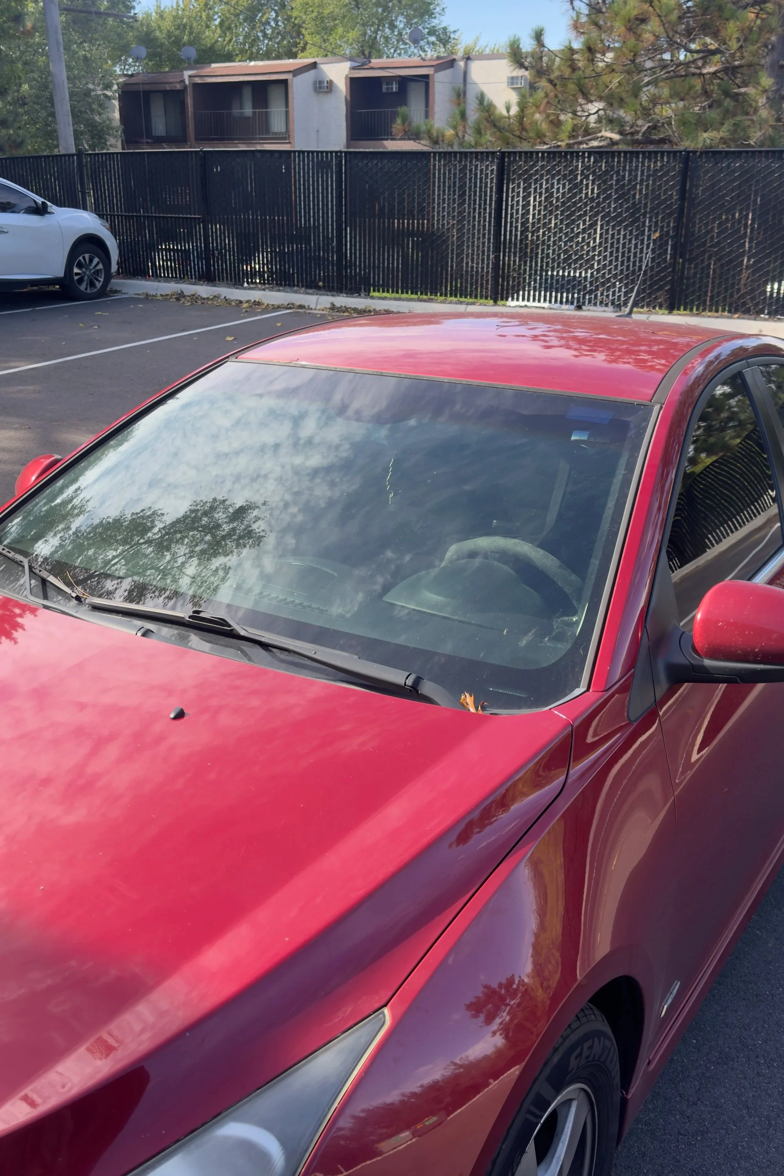 Red Chevrolet Cruze front windshield before tint installation