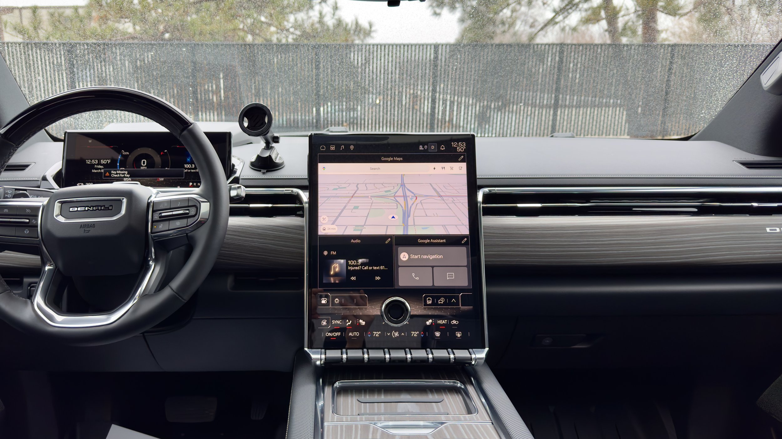 Vehicle dashboard with a steering wheel and a center touchscreen showing a navigation map.