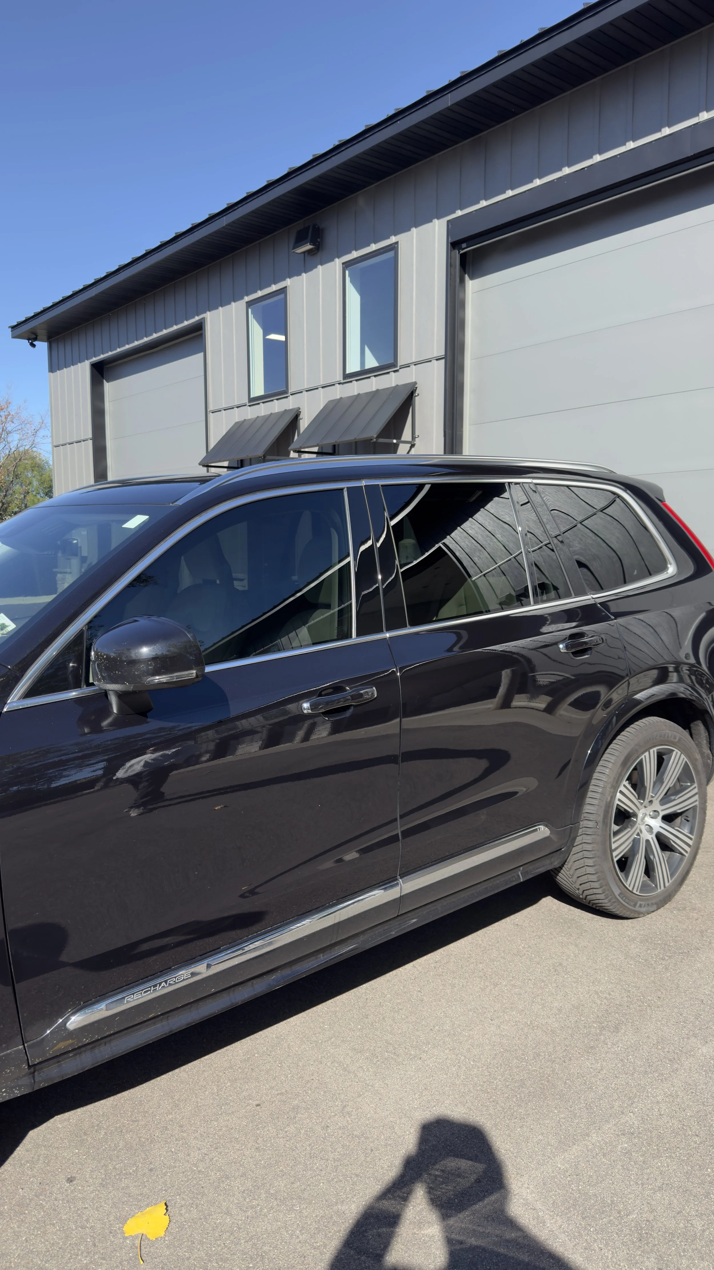 Black Volvo SUV with tinted side windows outside the shop