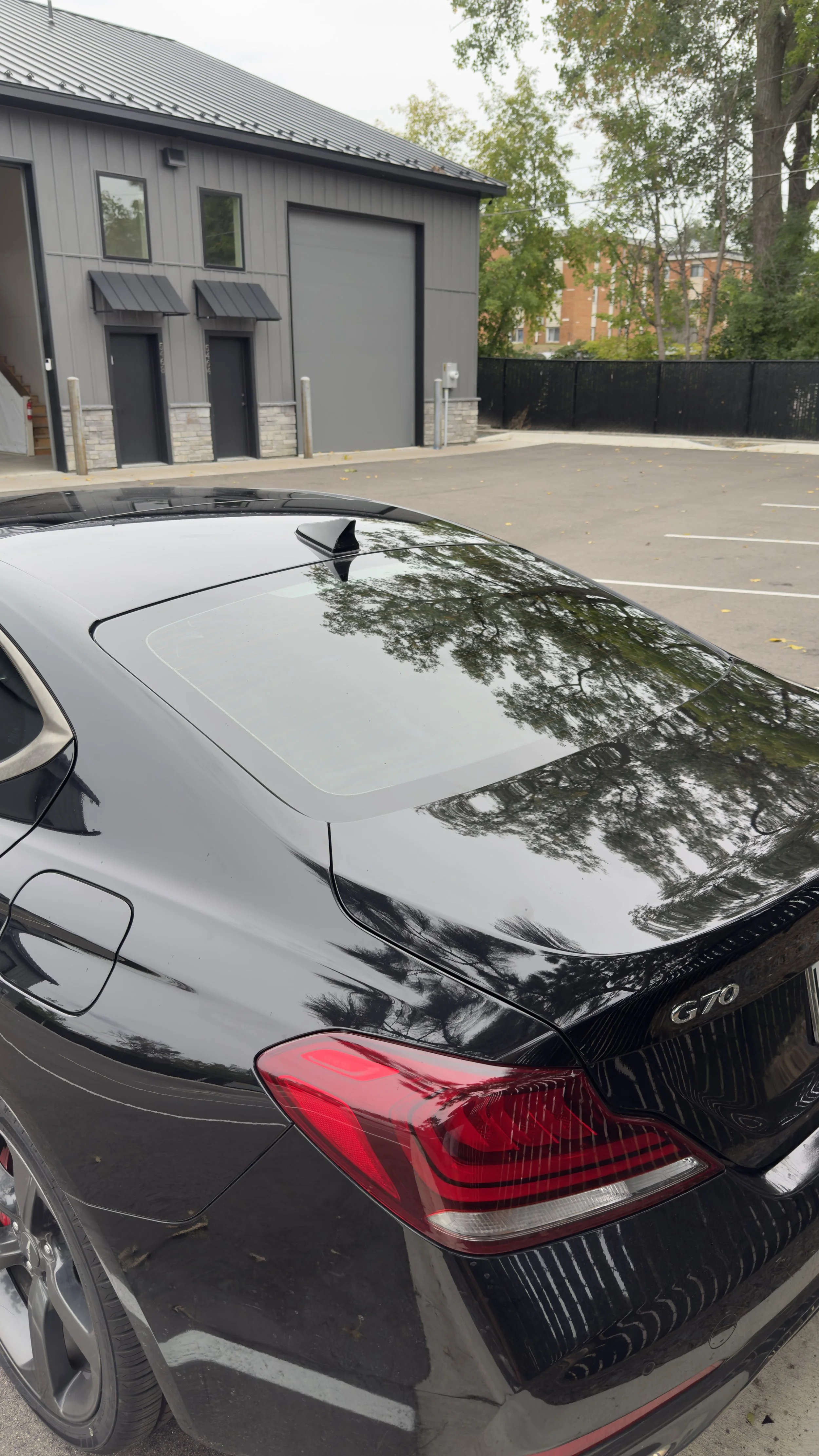 Black Genesis G70 with tinted rear windshield outside Blomker Detailing & Tint