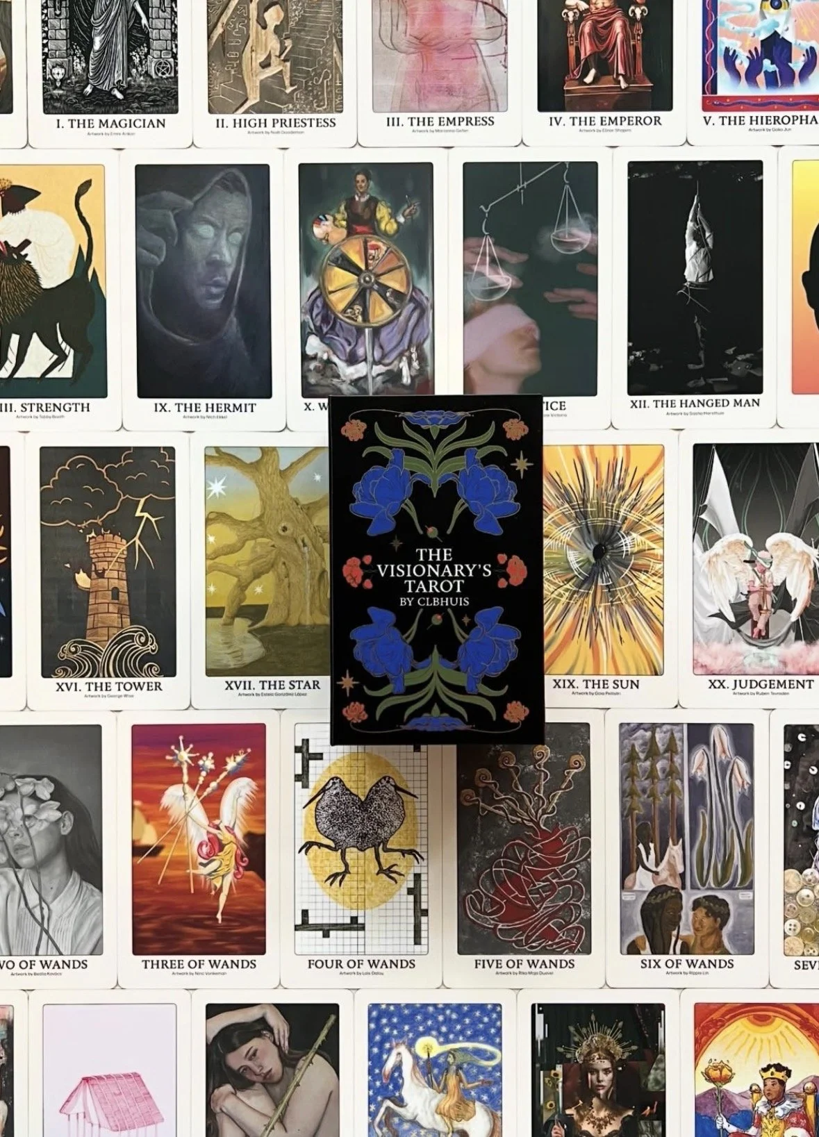 Cards from a tarot deck laid out on a surface, with a black card in the center titled "The Visionary's Tarot by CLBHUIS." Various tarot cards surrounding it depict different imagery and titles such as The Magician, The High Priestess, The Empress, The Emperor, The Hierophant, Strength, The Hermit, The Wheel of Fortune, The Hanged Man, The Tower, The Star, The Sun, The Judgment, and others.